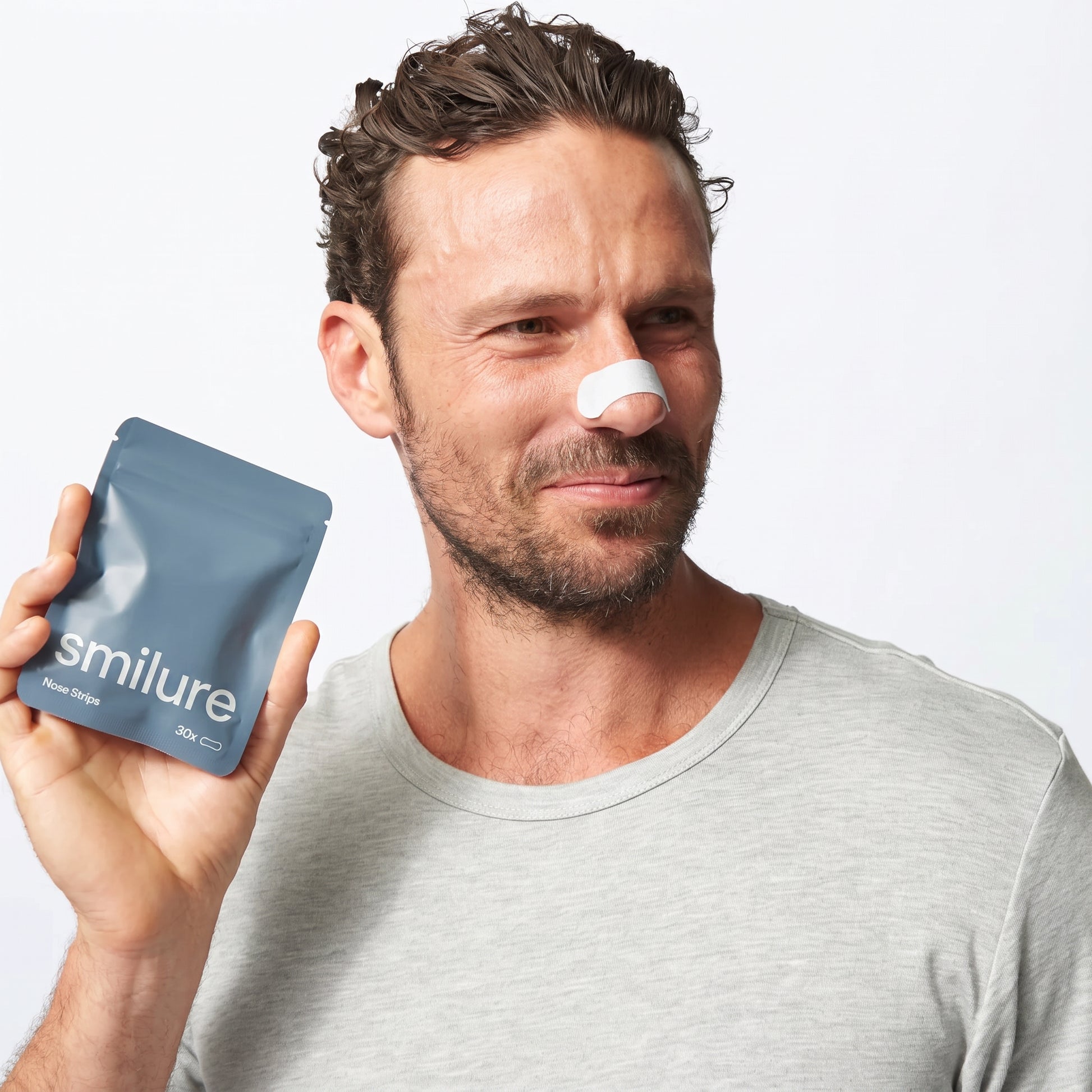 Man wearing Smilure nose strip holding pouch